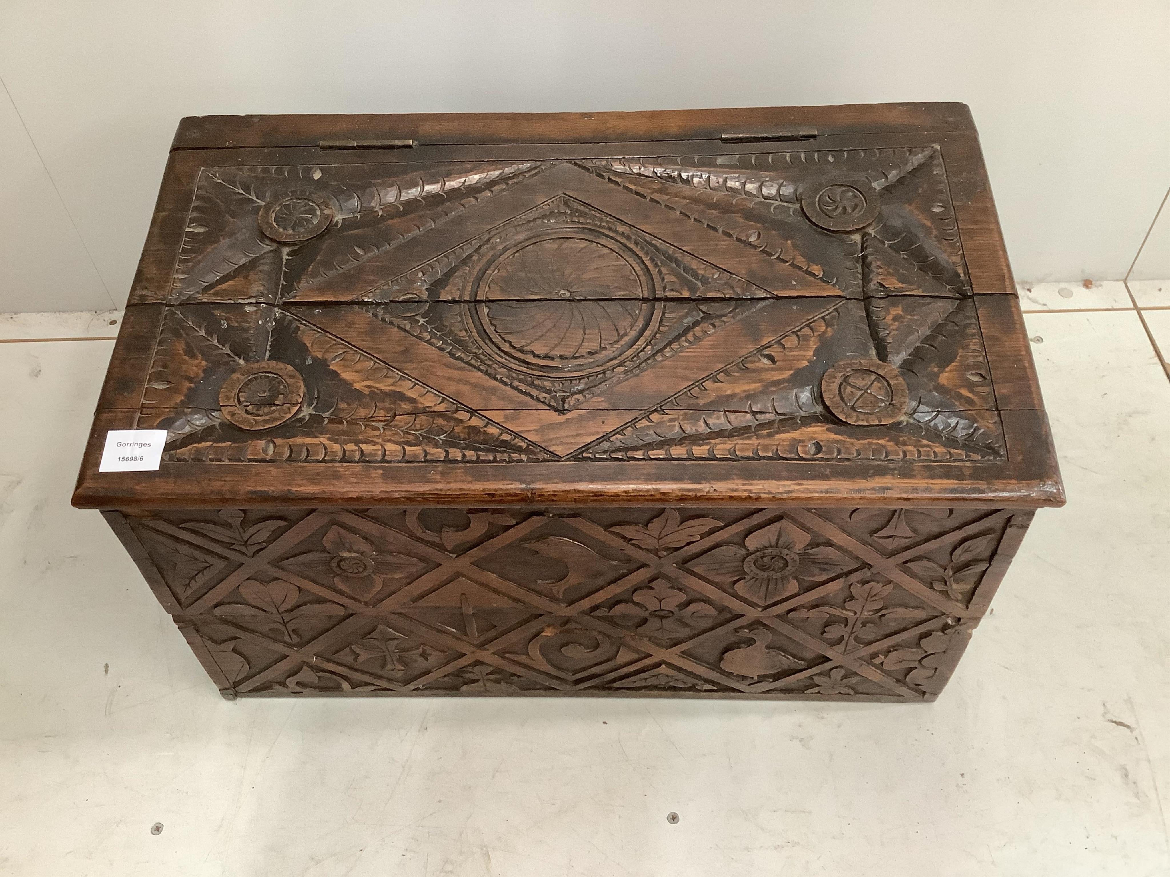 An early 20th century carved oak log bin, width 66cm, height 38cm. Condition - fair